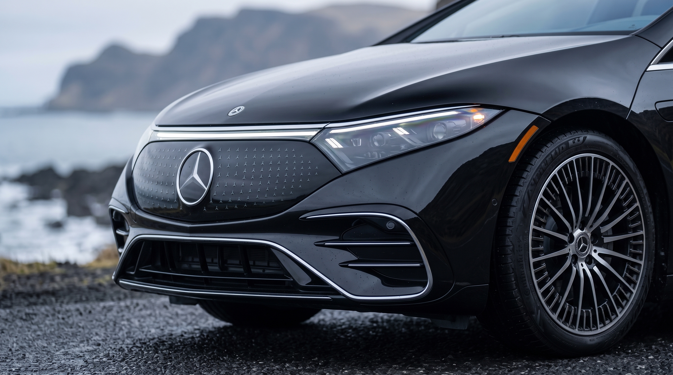 Detalhe da frente do Mercedes-Benz EQS — grelha iluminada, farol e janta